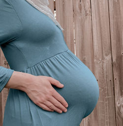 Midsection of woman touching wood