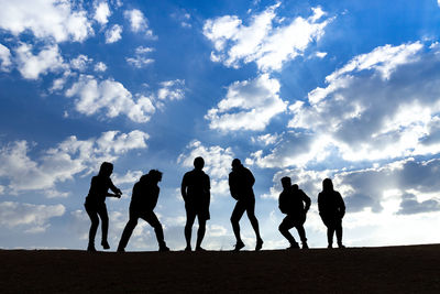 Silhouette people standing on land against sky