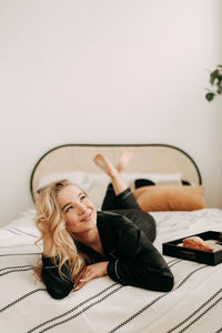 Young woman lying down on bed at home