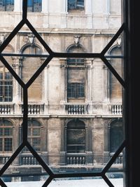 Low angle view of an historical building with large windows through a window 