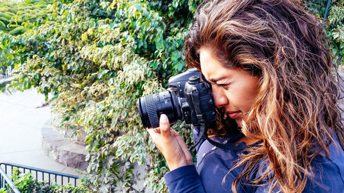 Young woman photographing with camera