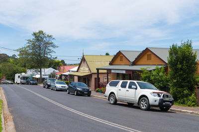 Cars on road by buildings against sky