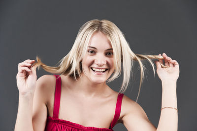 Portrait of a smiling young woman against black background