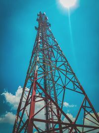 Low angle view of electricity pylon against blue sky