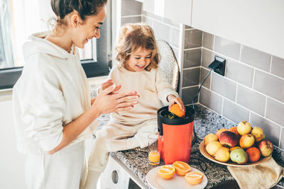 Side view of mother and female friends working at home