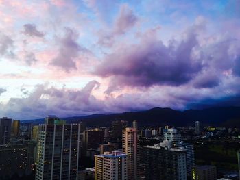 View of cityscape against cloudy sky