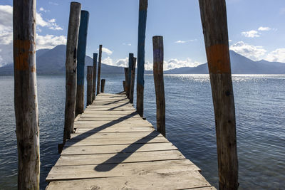 Wooden pier on sea against sky