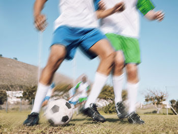 Low section of man playing soccer on field