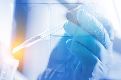 Cropped hand of scientist dripping chemical into test tube