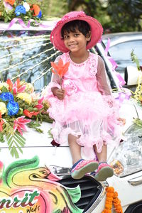 Full length of cute girl with pink flowers