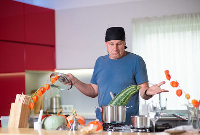 Man looking at vegetable in container on stove