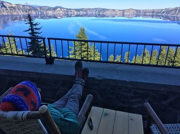 High angle view of man looking at lake while sitting on chair