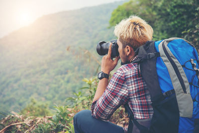 Close-up of young man photographing in forest