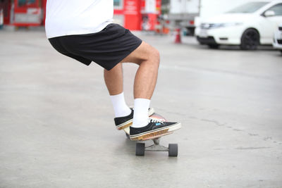 Low section of man skateboarding on street