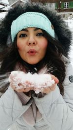 Close-up portrait of young woman in snow