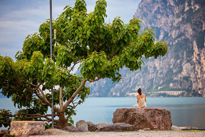 A serene and beautiful landscape featuring a person by the calm lake and majestic mountains