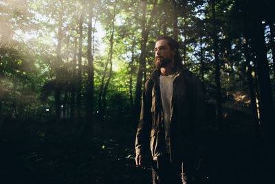 Man with beards standing in forest