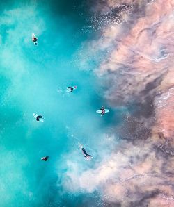 People flying over sea against blue sky