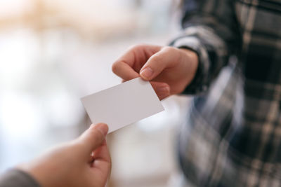 Close-up of businessman giving placard to colleague