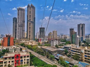 Aerial view of buildings in city against sky