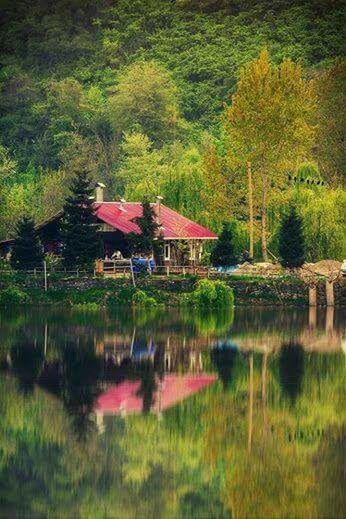 REFLECTION OF HOUSE IN CALM LAKE