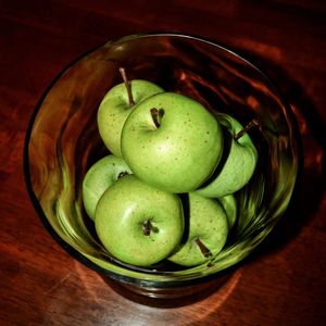 Bowl of green apples on table