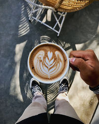 Low section of woman holding coffee cup