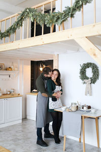 A happy couple in love are preparing for the christmas holiday in the decorated kitchen of the house