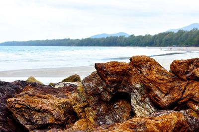 Rocks on beach against sky