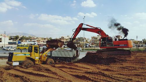 Bulldozer loading dump truck at construction site