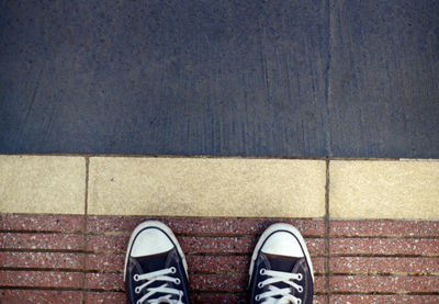 Low section of person standing on footpath