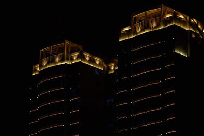 Low angle view of illuminated cityscape against sky at night