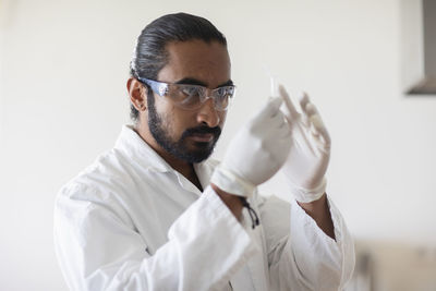 Young man scientist with lab coat checking a sample