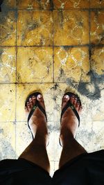 Low section of person standing on tiled floor