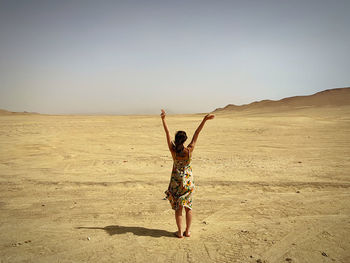 Full length of woman standing in desert