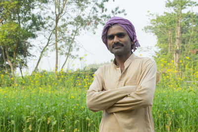 Portrait of young man standing on field