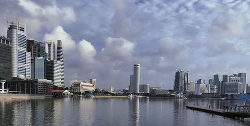 Sea by buildings against sky in city