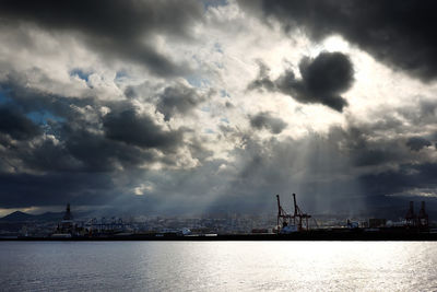 Sunlight streaming through storm clouds over city