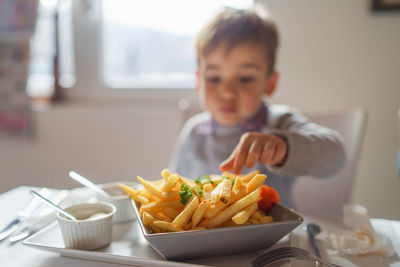 Boy eating food on table