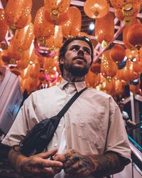 Low angle view of man standing by lanterns