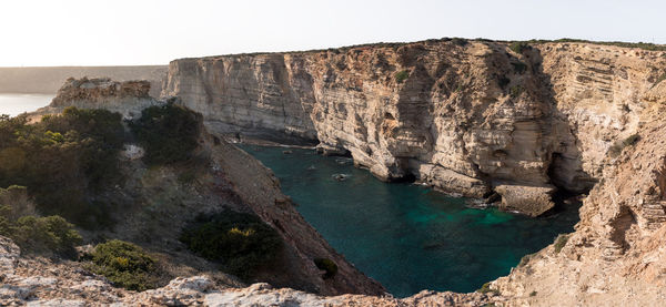 Rock formations by sea against sky