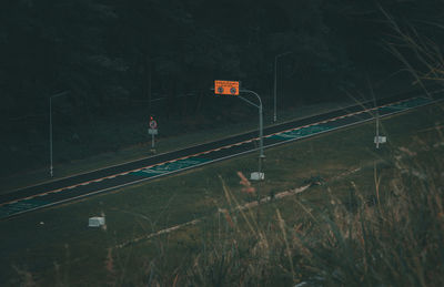 Information sign by railroad tracks at night