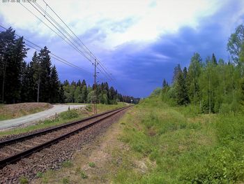 Railroad track amidst trees against sky