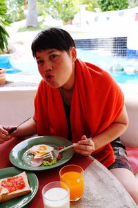 Portrait of woman having food while sitting at restaurant