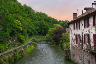 River amidst trees and buildings against sky