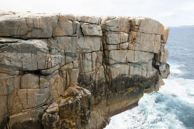 Rock formations by sea against sky