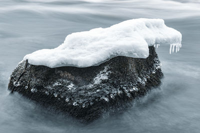 Ice on stone in winter river