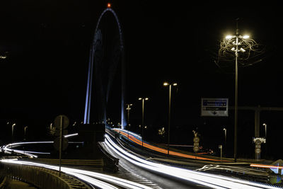 Light trails on road against sky at night