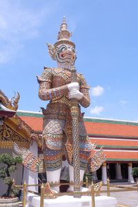 Low angle view of statue against temple building