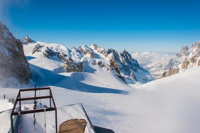 Scenic view of snowcapped mountains against blue sky